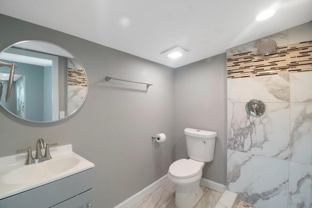 bathroom featuring vanity, toilet, and a tile shower