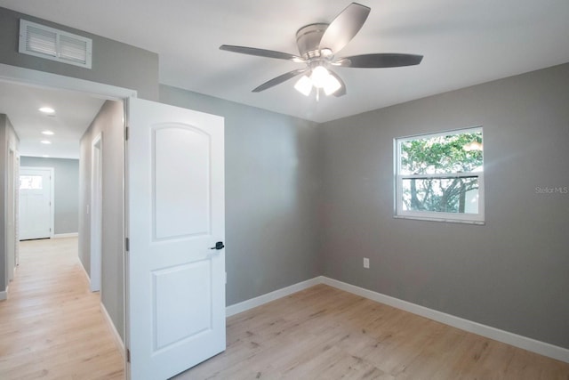 empty room with ceiling fan and light wood-type flooring