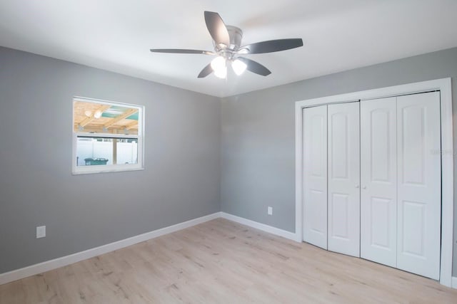 unfurnished bedroom with ceiling fan, light wood-type flooring, and a closet