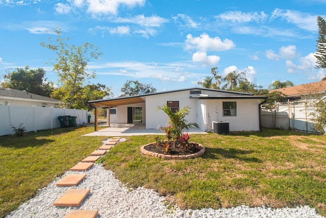 rear view of property featuring cooling unit, a yard, and a patio area