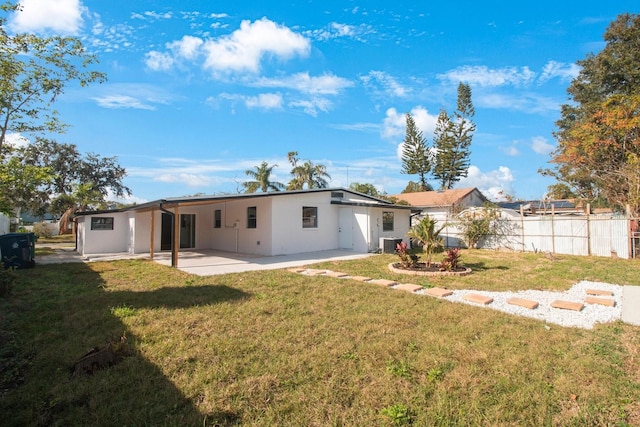 rear view of property with a yard, a patio, and central air condition unit