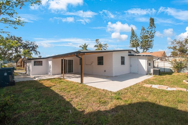 rear view of house with a patio, cooling unit, and a lawn