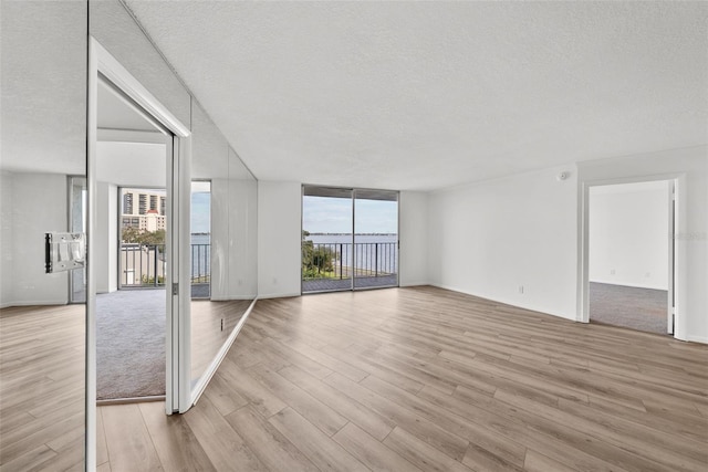 empty room with light hardwood / wood-style floors and a textured ceiling