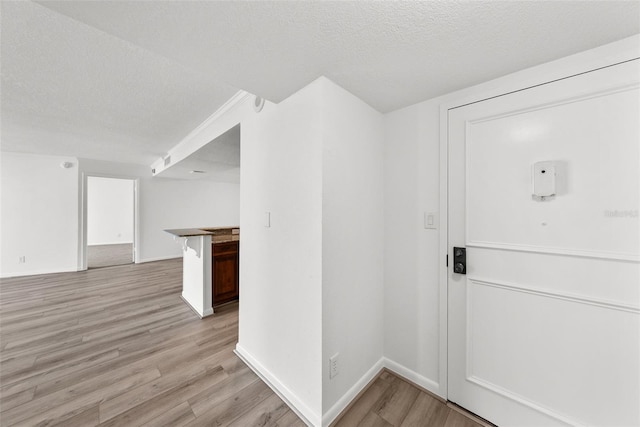 entrance foyer with light hardwood / wood-style floors and a textured ceiling