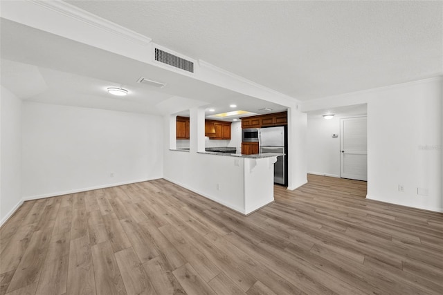 unfurnished living room featuring a textured ceiling, light hardwood / wood-style floors, and ornamental molding