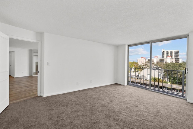 carpeted empty room with a textured ceiling