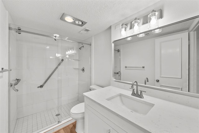 bathroom featuring hardwood / wood-style floors, a textured ceiling, toilet, a shower with door, and vanity