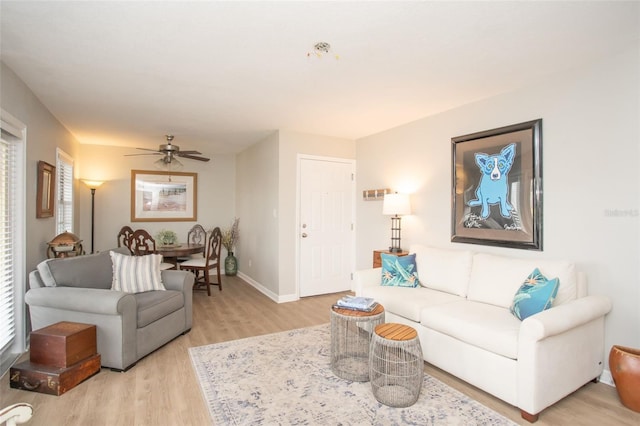 living room featuring ceiling fan and light hardwood / wood-style floors