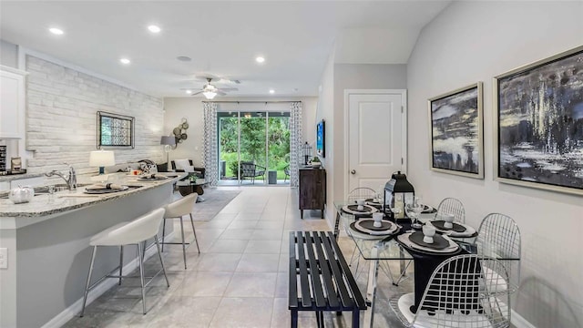 dining space with light tile patterned floors, ceiling fan, and sink