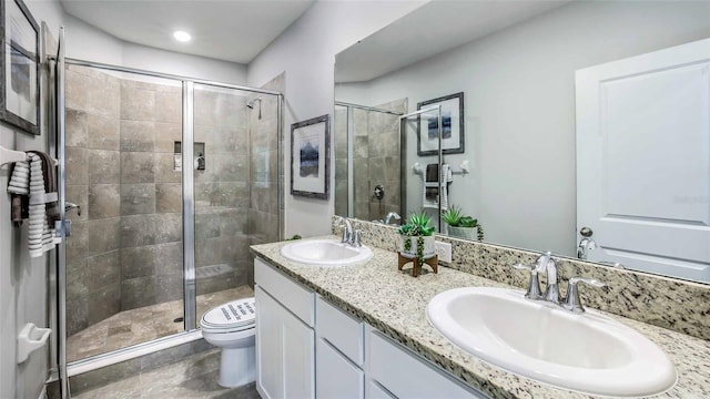 bathroom with vanity, toilet, and a shower with door