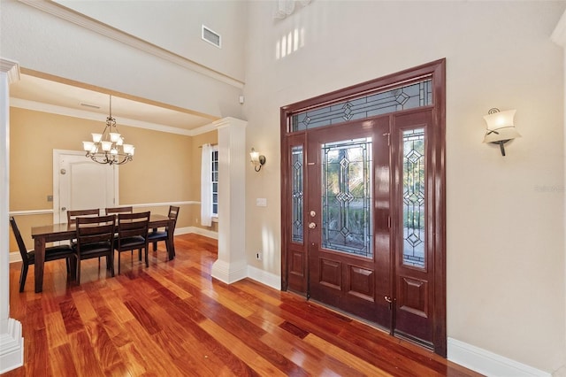 foyer entrance featuring crown molding, a chandelier, and hardwood / wood-style flooring