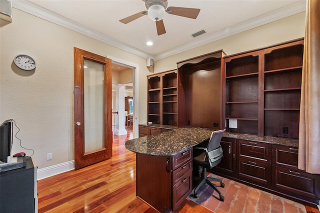 office area featuring built in desk, light wood-type flooring, ceiling fan, and crown molding