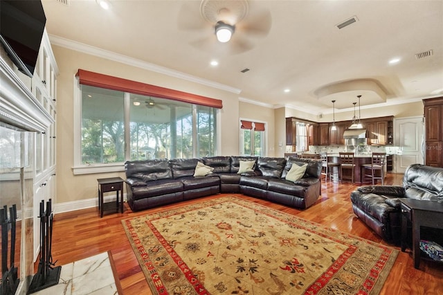 living room featuring crown molding, a healthy amount of sunlight, and wood-type flooring