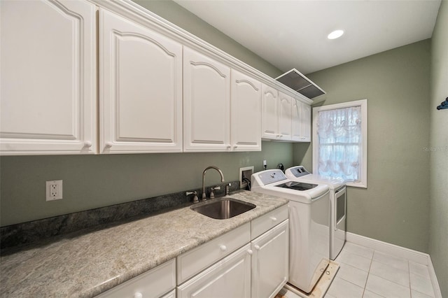 clothes washing area featuring washing machine and clothes dryer, sink, light tile patterned floors, and cabinets