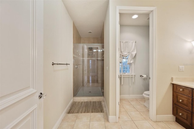 bathroom with tile patterned floors, vanity, toilet, and walk in shower