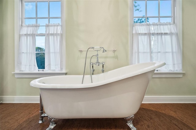 bathroom with hardwood / wood-style flooring and a washtub