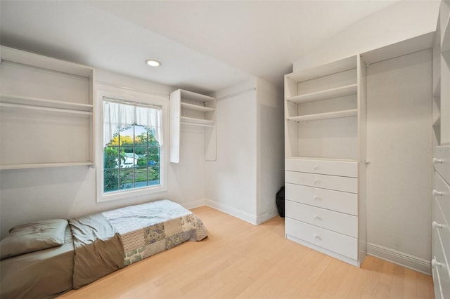 walk in closet with lofted ceiling and light wood-type flooring