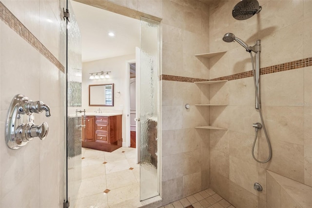 bathroom with tile patterned floors, vanity, and a tile shower