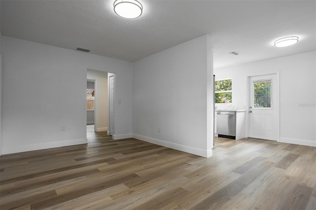 empty room featuring hardwood / wood-style flooring and a textured ceiling