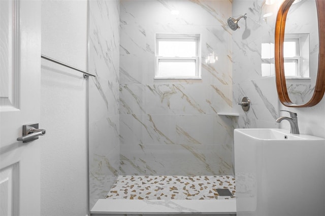 bathroom featuring tiled shower and a wealth of natural light