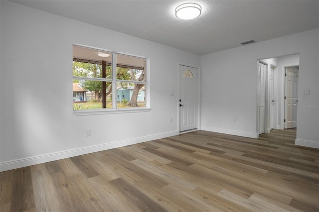 spare room featuring hardwood / wood-style floors and a textured ceiling