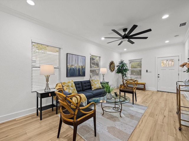 living room with ceiling fan, light wood-type flooring, and ornamental molding