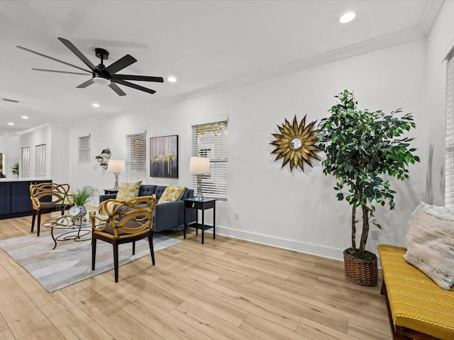 living room with ceiling fan, ornamental molding, and light hardwood / wood-style flooring