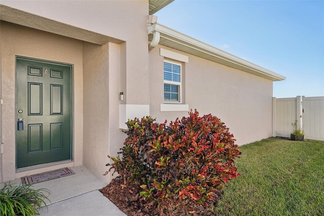 entrance to property featuring a lawn