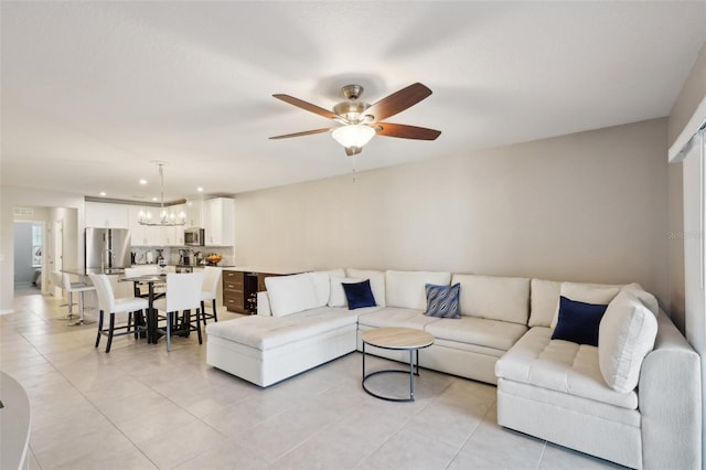 tiled living room featuring ceiling fan with notable chandelier