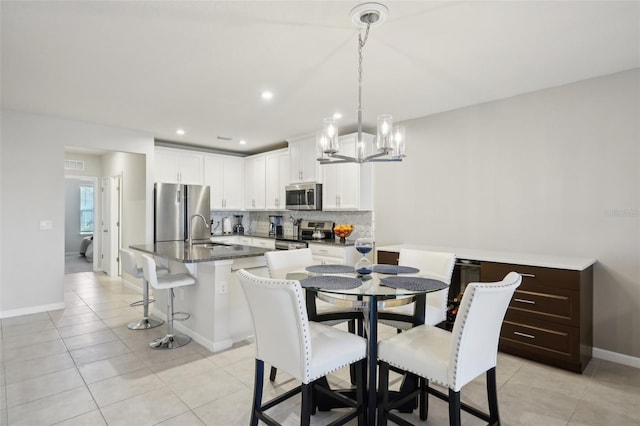 dining space featuring sink and light tile patterned floors