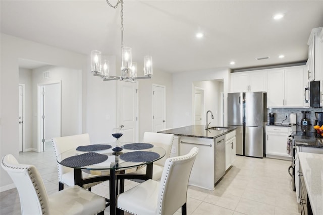 tiled dining room featuring sink and an inviting chandelier