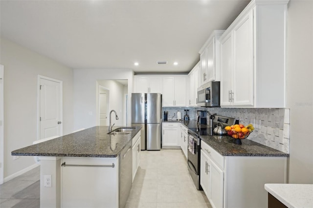 kitchen featuring a center island with sink, sink, white cabinetry, and stainless steel appliances