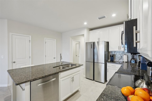 kitchen featuring sink, stainless steel appliances, light tile patterned floors, a kitchen island with sink, and white cabinets