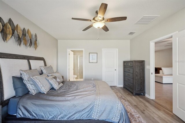 bedroom with ceiling fan, hardwood / wood-style floors, and ensuite bathroom