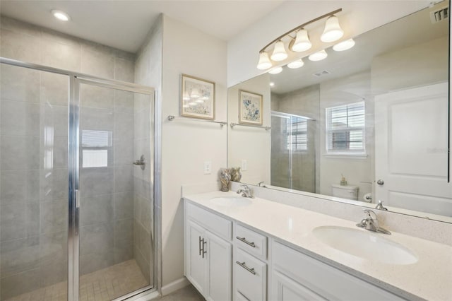 bathroom featuring vanity, toilet, and walk in shower