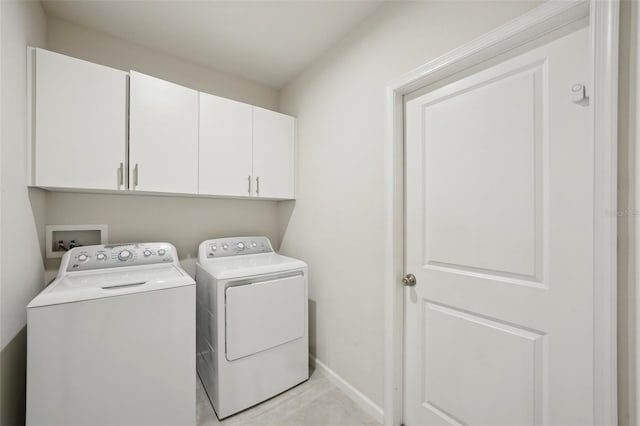 washroom featuring cabinets and separate washer and dryer