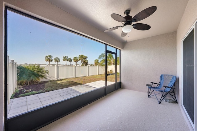 unfurnished sunroom with ceiling fan