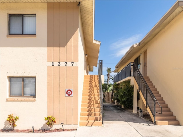 exterior space featuring stairway and stucco siding