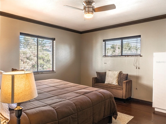 bedroom with baseboards, ornamental molding, a textured wall, dark wood-style floors, and a ceiling fan