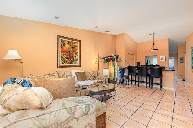 living room featuring light tile patterned floors, baseboards, and vaulted ceiling