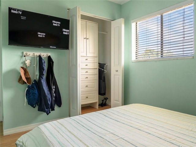 bedroom featuring baseboards and wood finished floors