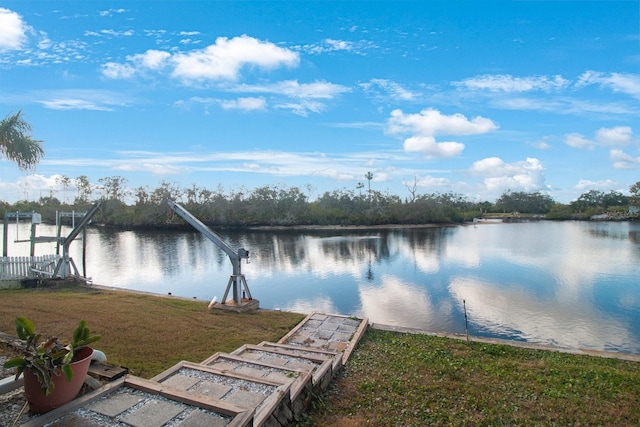 view of dock with a water view and a lawn