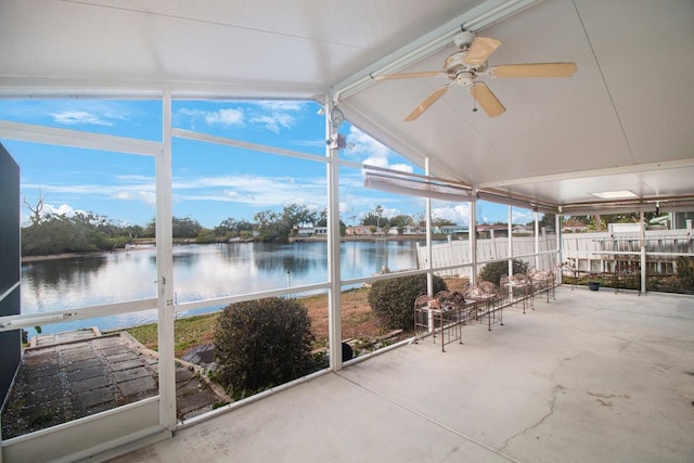 unfurnished sunroom with ceiling fan, a water view, and vaulted ceiling