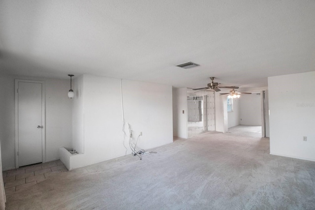 carpeted spare room featuring a textured ceiling and ceiling fan