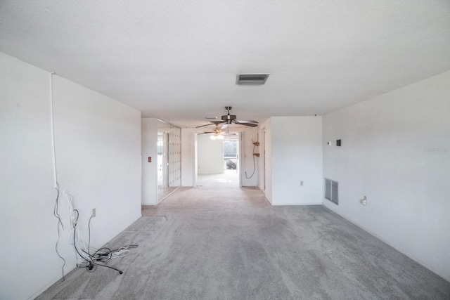 carpeted spare room featuring ceiling fan and a textured ceiling