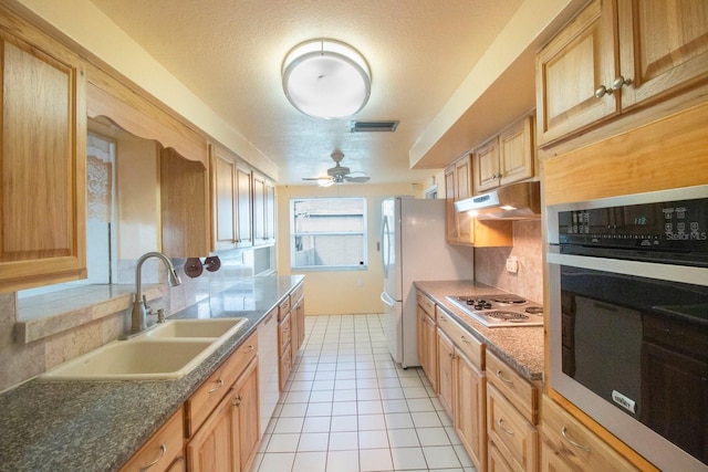 kitchen featuring white appliances, sink, ceiling fan, a textured ceiling, and light tile patterned flooring