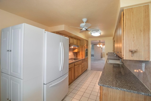 kitchen with sink, ceiling fan, decorative backsplash, light tile patterned floors, and stainless steel appliances