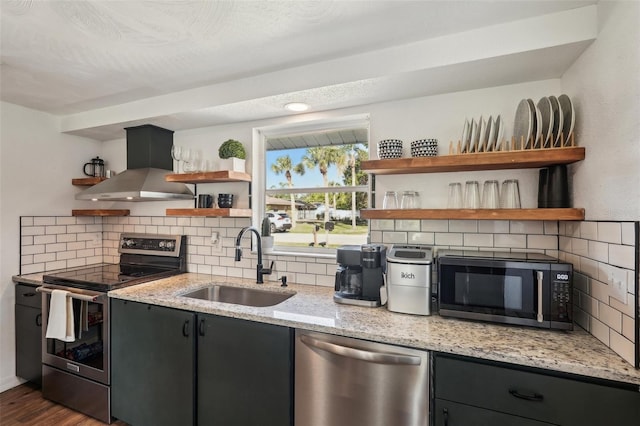 kitchen featuring light stone countertops, sink, wall chimney exhaust hood, dark wood-type flooring, and stainless steel appliances