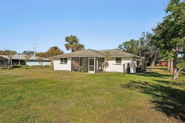 back of property with a lawn and a sunroom