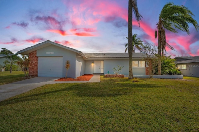 single story home featuring a yard and a garage